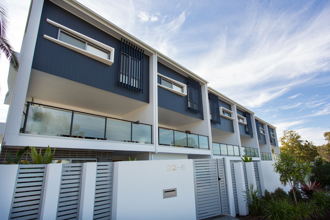 Modern, 3-story townhouse development at Seven Hills. Blue, grey and white colour theme, with glass balustrades on 2nd level.