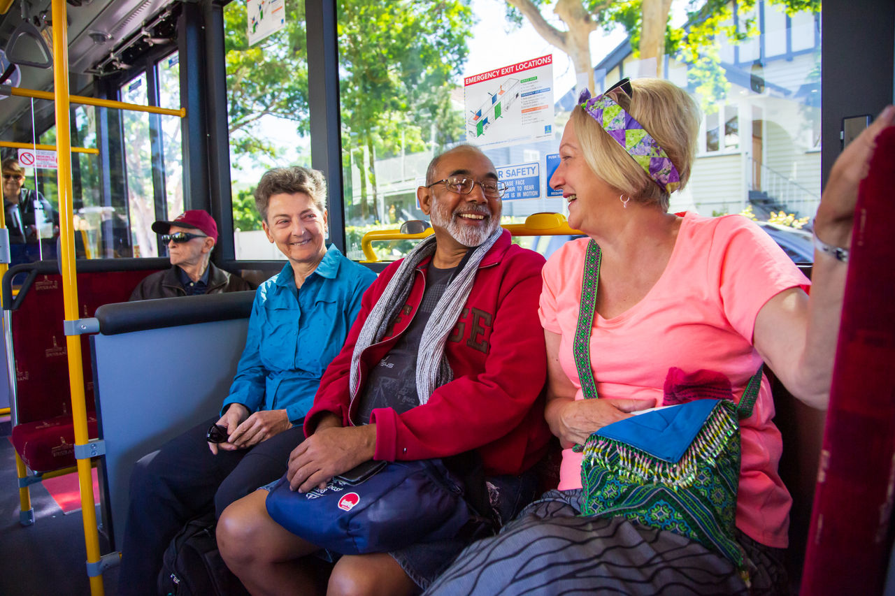 Three seniors sitting talking on a Council bus.