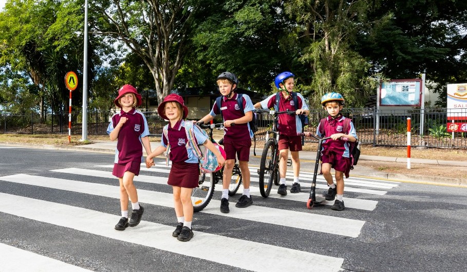 Group of school children walking across a zebra crossing