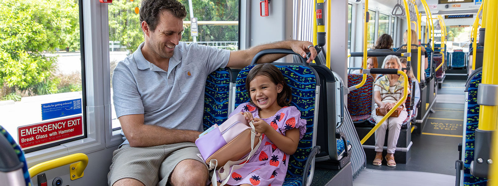 Father and daughter smiling on metro