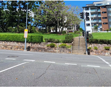 Road intersection with hedges and stairs on pathway